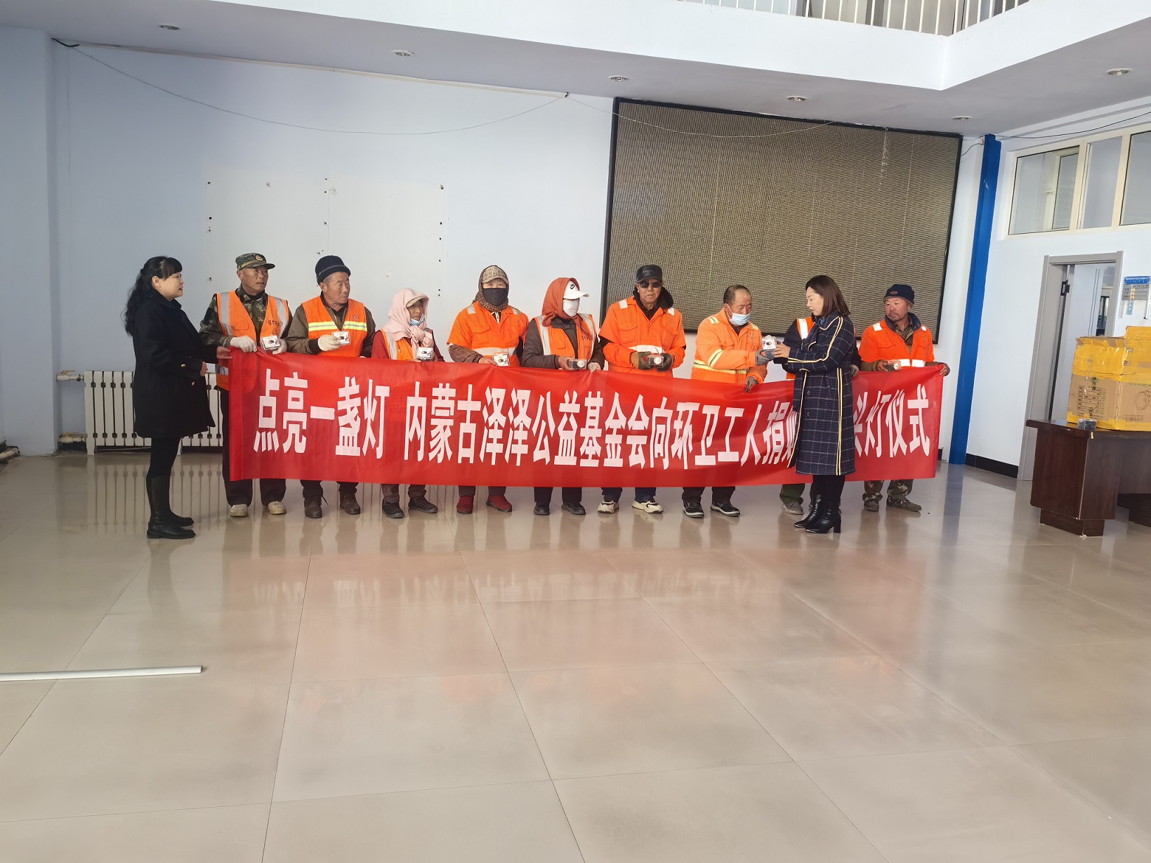 基金会工作人员向环卫工人介绍警示头灯充电使用及正确佩戴方法（王彩娟拍摄）.jpg
